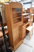 A natural pine bookcase having glazed top and open shelves under