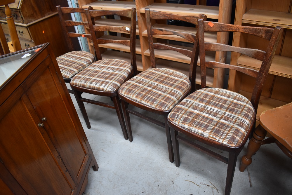 A set of four mid century bent wood dining chairs with arched ladder backs