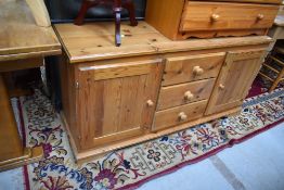 A vintage pine sideboard having three central drawers