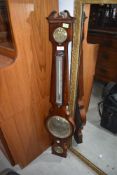 An antique murcury filled barometer having mahogany case and brass painted dials