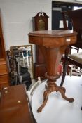 A ladies sewing table having internal compartments and burr wood top with tapered body and carved