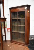 An Edwardian corner cupboard having rolled glass front