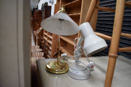 A white angle light and similar brass glass shade desk lamp