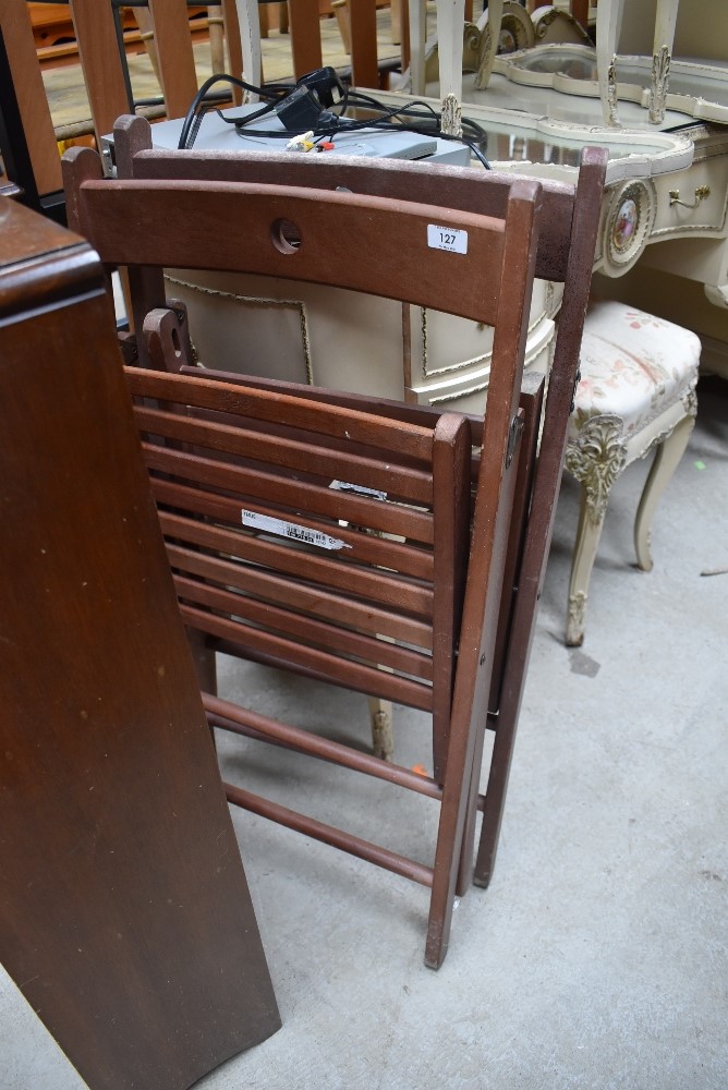 A pair of fold away teak or similar wood chairs