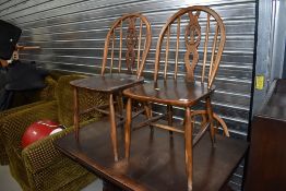 A set of four dark stained Ercol 'fleur de lys' kitchen chairs