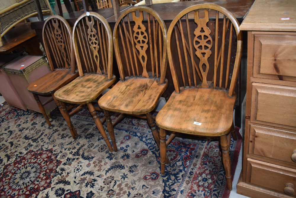 A set of four traditional stained frame wheelback dining chairs