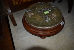 A circular framed wool topped footstool