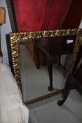 A gilt framed hall way mirror