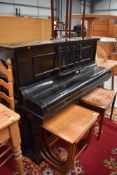 A tracditional upright piano having ebonised case, labelled and impressed for Duck , Son & Pinker