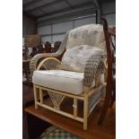 A modern canework conservatory easy chair with upholstered seat and back