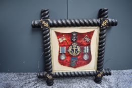 A ornately framed Medal Group with two naval badges, Royal Naval Long Service and Good Conduct Meda