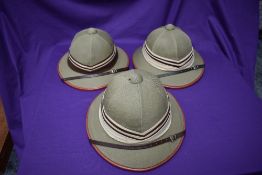 Three Kharki Pith Helmets, size 57 x2 and 58 all with cream and brown band, all with chin straps