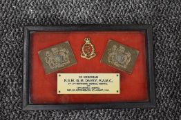 A framed WW2 Memorial consisting of two shoulder badges, cap badge and plaque reading In Memoriam