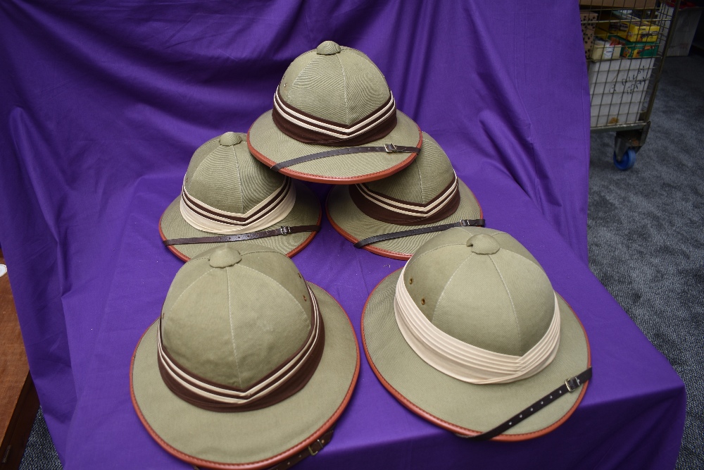 Five Kharki Pith Helmets, size 57, 58, 59, 60 & 61 all with cream and brown band, all with chin