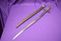 A French Sabre Bayonet model 1859 with re-curved blade, solid brass hilt and metal scabbard, named