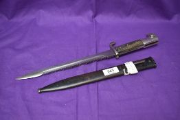 A German Model 1898 Saw Back Dress Bayonet with three rivet chequered grip, no maker mark seen,