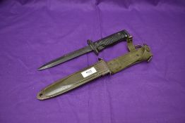 An American M5 Bayonet for the Garand Rifle with metal scabbard and webbing frog, bayonet marked