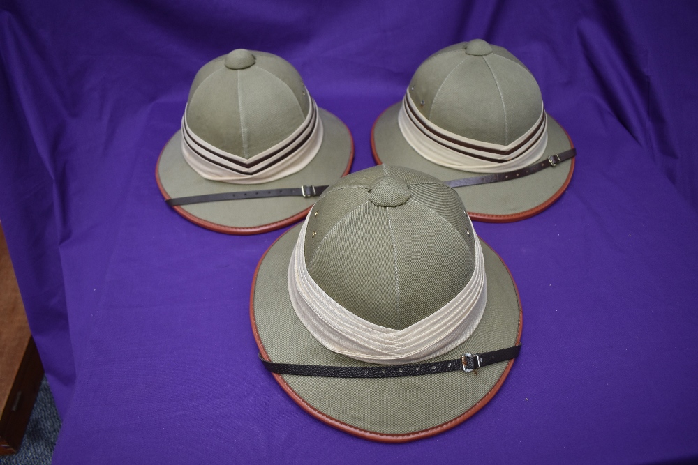 Three Kharki Pith Helmets, size 57 x2 and 58 all with cream and brown band, all with chin straps
