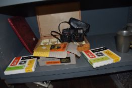 A vintage Johnson Jumbo 22 viewer, two reels of Emitape a slide box and a a Konica camera.