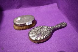 An HM silver backed clothes brush having engine turned stripe decoration and plain cartouche and