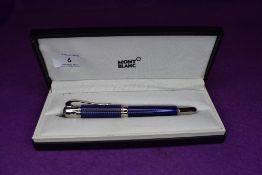 A Mont Blanc roller ball pen having blue check pattern to barrel.