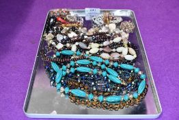 A small selection of costume broaches and strings of beads