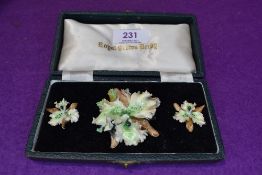 A cased set of Royal Crown Derby porcelain jewellery comprising broach and clip earrings in the form