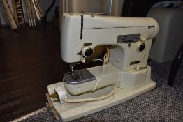 A sewing machine in hard case by Neechin