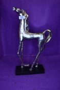 A sculpted figure of a wild horse in metal and weld on wooden base