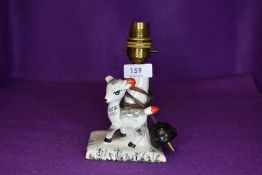 A mid century small ceramic table lamp having kitsch style figure of foal