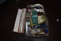 A box of vintage and retro belts and accessories and a lace fan.