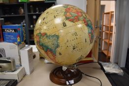 A light up globe of the world having World Discoverer map and city population