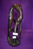 An unusual ethnic wood treen carved figure or totem of an creature eating itself