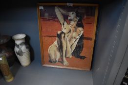 A framed and glazed needlepoint depicting and nude brunette.