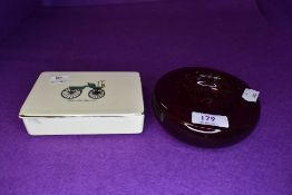 A ruby red control bubble glass dish and ceramic lidded container with transport imagery