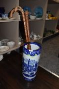 An antique blue and white ceramic stick/umbrella stand having transfer pattern of town scene,also