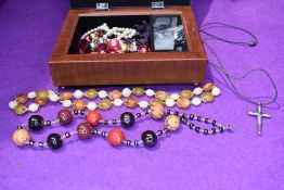 A musical jewellery box containing a small selection of costume jewellery necklaces