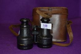 A pair of early brass bodied binoculars with matching leather case