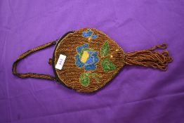An early 20th century beaded bag having fringing to bottom and clasp fastening.