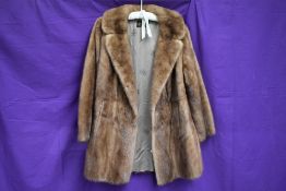 A vintage mink coat having half belt to back, around a medium size.