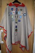 A wonderful vintage poncho having crotched edges and a good assortment of girl guides and similar b