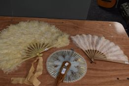 Three vintage and antique fans, two feathered and one paper with mirror to carved wood centre.