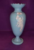 An antique blue glass vase having white enamel classically styled maiden to front.