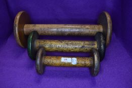 Four large vintage wooden bobbins, John Dixon and sons labelled to one.