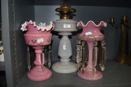 Two antique pink glass mantel lustre's and a oil lamp.