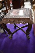 A 19th Century Chinese square top carved table having typical foliate and animalistic decoration