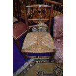 A 19th Century spindle back chair with rush seat, some historical worm to lower rail