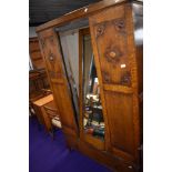 An early 20th Century oak mirror door wardrobe