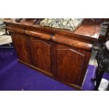 A Victorian mahogany sideboard, having ledge back, three frieze drawers, and triple cupboard