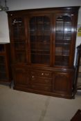A reproduction oak bookcase, of nice quality having glazed top over drawer and cupboard base,